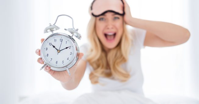 Oh no I late. Photo of crazy shocked fear lady sitting bed sheets holding metal alarm clock morning missed work oversleep afraid be fired hand on head screaming wear pajama room indoors