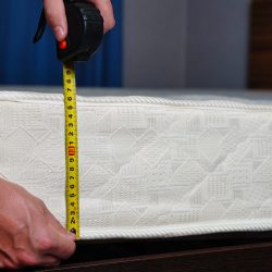 Measuring the height of the mattress with a measuring tape. Comfortable sleep orthopedic bed. High quality photo