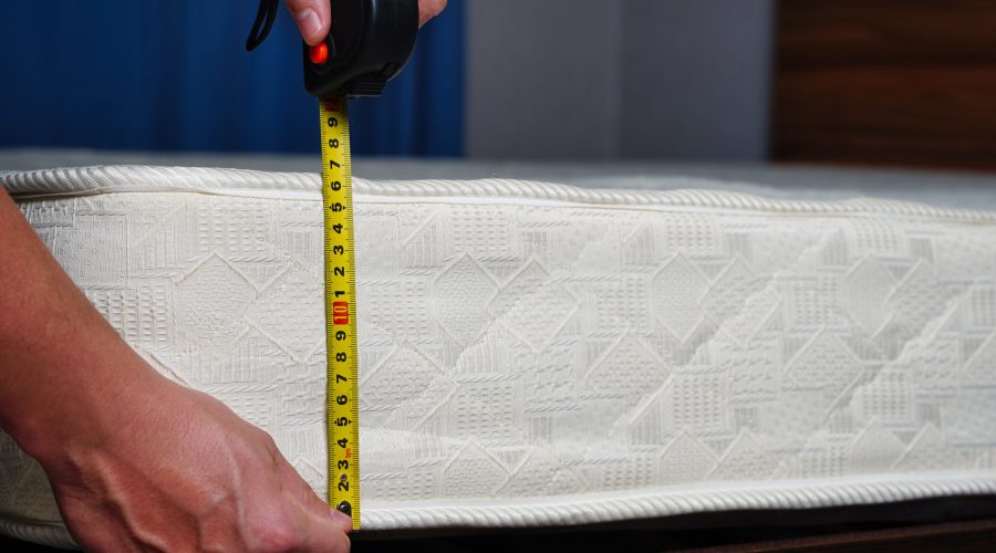 Measuring the height of the mattress with a measuring tape. Comfortable sleep orthopedic bed. High quality photo