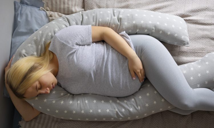 top-view-pregnant-woman-using-nursing-pillow